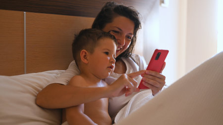 Happy young mother with little son using smart phone together. High quality photoの写真素材