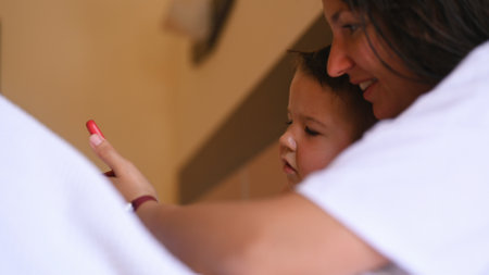 Happy young mother with little son using smart phone together. High quality photoの写真素材