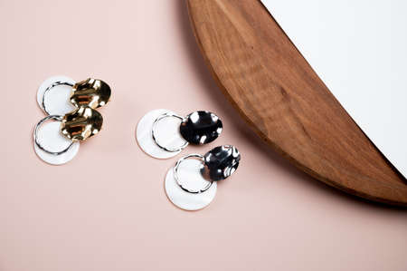 Trendy stylish jewelry on pink background. Earrings with pendants and pearl. High quality photoの写真素材