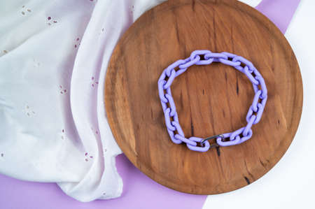 Violet chain choker on round wooden stand. Stylish women's jewelry. Fashion concept. High quality photoの写真素材