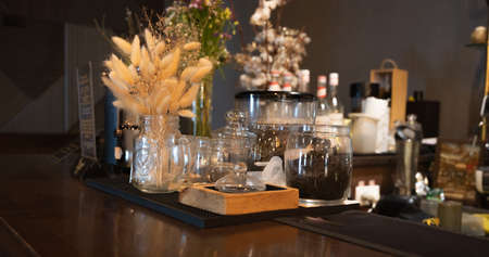 Tea in glass jars. Bar counter in a cafe. The interior of the bar is in dark shades. High quality photoの写真素材