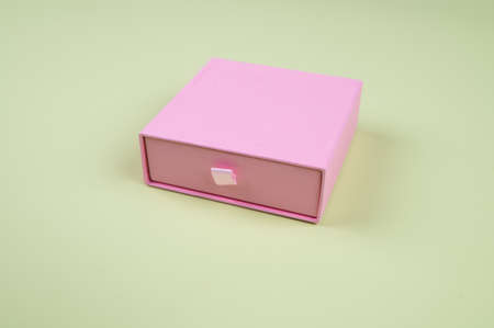 Pink carton cardboard box on pastel green background, side view. High quality photoの写真素材