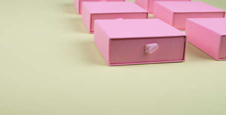 Lot of square pink carton boxes on green background. High quality photoの写真素材