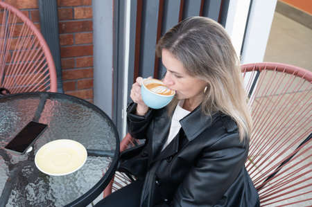 Woman drinking coffee in a cafe outdoors