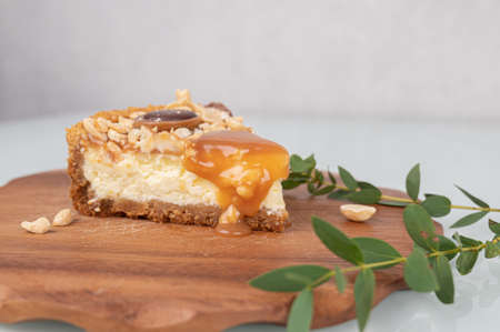Slice of peanut caramel cheesecake on wooden stand. High quality photoの写真素材