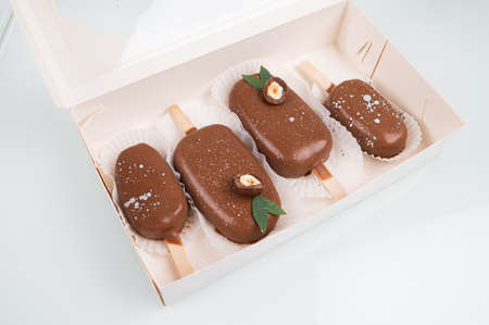 Chocolate cake pops in the form of ice cream on a stick. On a wooden stand, top view. Concept food,...