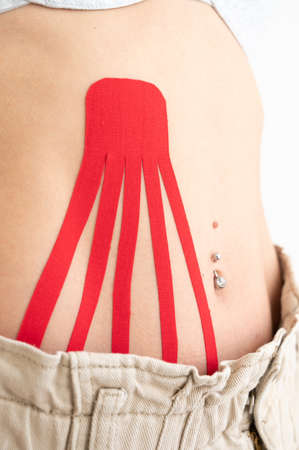 Close-up of sexy body with tape on the abdomen of young girl. Sport tratment and skin care
