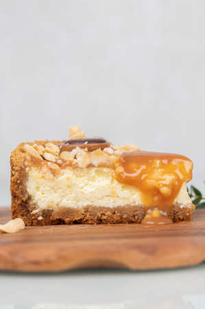 Close-up of a piece of cheesecake with nuts and dripping caramel. Homemade baking concept.の写真素材