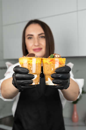 Confectioner woman holding delicious cookie dough trifle in hands.の写真素材