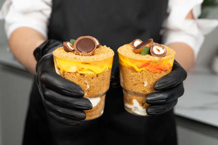 Cropped view of confectioner woman holding delicious cookie dough trifle in hands