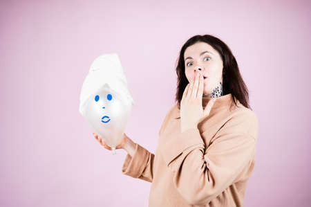 Spa girl. Emotional woman covers her mouth in surprise on pink background. gift certificate concept.