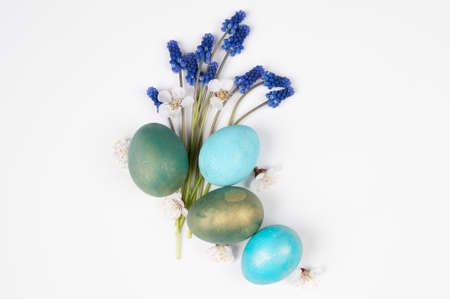 Spring Easter greeting card. Easter eggs with blue flowers isolated on white, top view.