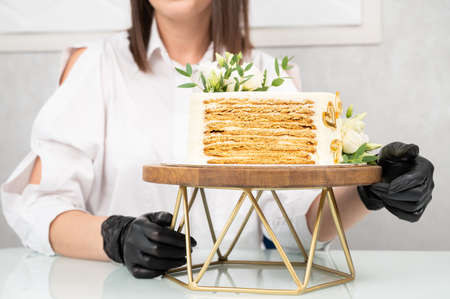 Young caucasian girl holding birthday cake over isolated white background, close up.の写真素材