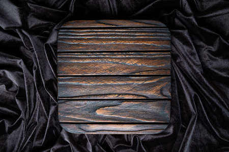 Dark brown square wooden podium for product display on wavy velvet background. Empty textured wooden stand, top viewの写真素材