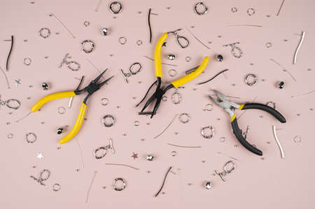 Jewelry making tools and accessories on pastel pink background. accessories for making jewelry....