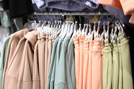 Women clothing in pastel colors on hangers in a boutique store. Sale of women's clothing. Casual style.の写真素材