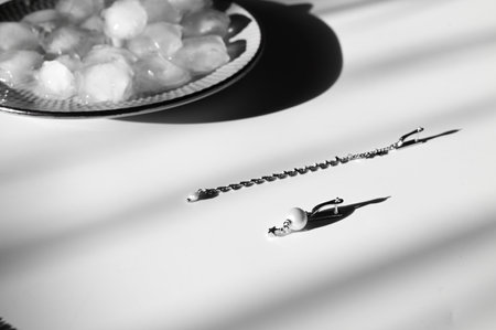 Women's jewelry and ice on gray background with shadow. Silver earrigs and chain necklace. bijouterie.の写真素材