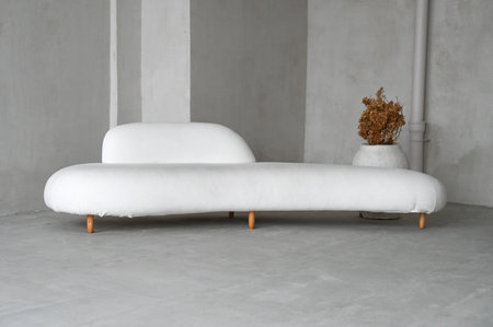 Design composition of living room interior with white sofa over concrete wall. Stylish home decor