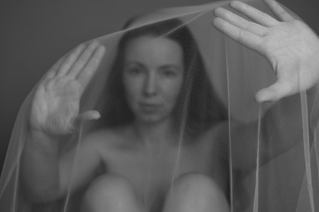 Woman under white veil posing sensually with outstretched palms. Stop violence against Women,sexual...
