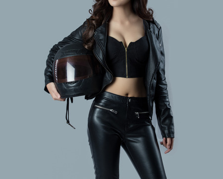 beautiful female biker wearing a leather jacket - in studioの写真素材