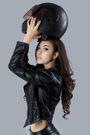 beautiful female biker wearing a leather jacket - in studioの写真素材