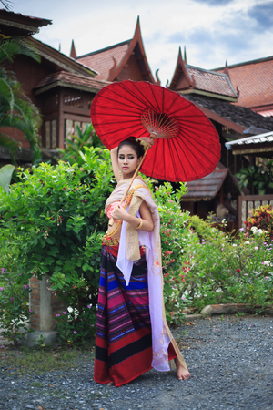 Thai Woman In Traditional Costume Of Thailand with umbrellaの写真素材