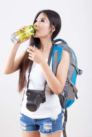 Beautiful woman traveler drinking water - on white backgroundの写真素材