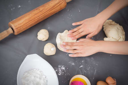 Female hands baking dough on the tableの写真素材