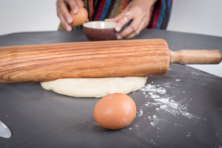 Female hands baking dough on the tableの写真素材
