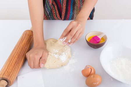 Female hands baking dough on white backgroundの写真素材
