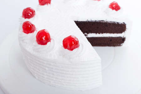 Chocolate cake with cherry on top - white backgroundの写真素材
