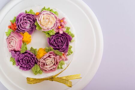 Delicious creamy cake with flowers - on white background