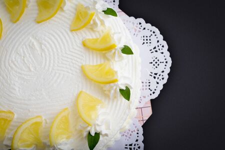 Lemon cake and piece of lemon on black backgroundの写真素材