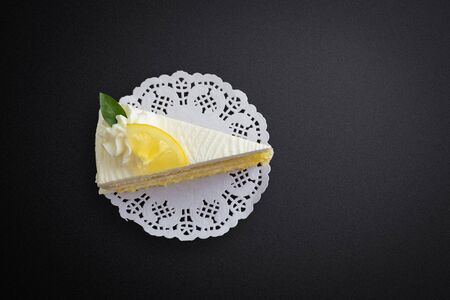 Lemon cake and piece of lemon on black backgroundの写真素材