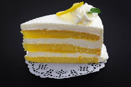 Lemon cake and piece of lemon on black backgroundの写真素材