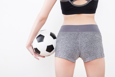 Sexy woman body in sports ware with soccer ball isolated on white backgroundの写真素材