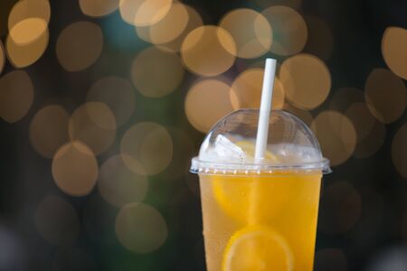 Close up Lemon iced tea in takeaway glass  - bokeh background