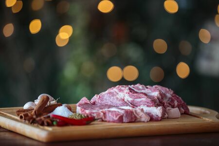 Close up raw pork with herbs on cutting board - bokeh backgroundの写真素材