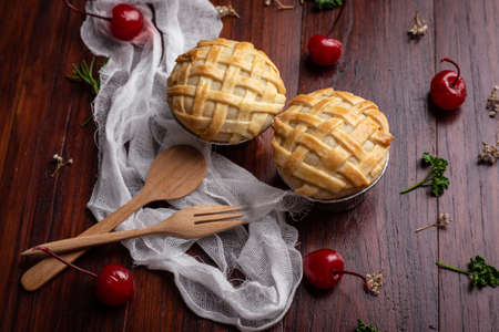 Mini coconut pie  with red cherry on wooden table. Homemade Bakery concept.