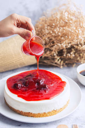 Ice box cheese cake with strawberry jam and a cup of coffee on the table. Homemade cheese cake.