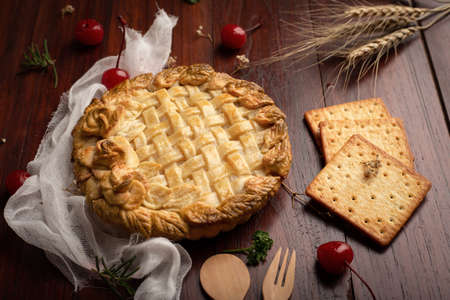 Apple pie  with red cherry on wooden table. Homemade Bakery concept.の写真素材