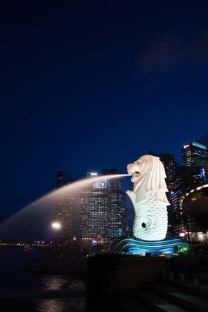 Merlion on twilight with high tower background, portrait, Singaporeのeditorial素材