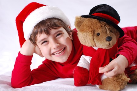 Christmas kid in Santa hat with teddy bearの写真素材
