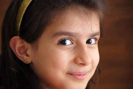 A young girl smiling and looking at youの写真素材