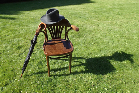 Hat, umbrella and a chair on the grassの写真素材