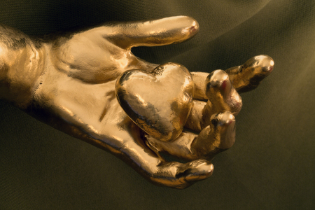 golden heart in the golden handの写真素材