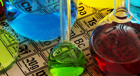 Laboratory glassware with color solutions on the table of the chemical elementsの写真素材