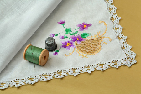 Thread with a needle, a thimble and a handkerchief