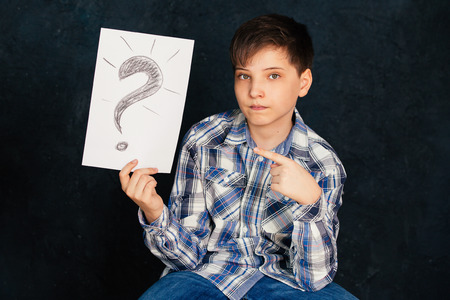 The boy sits, a clean sheet, in the Studio. Background.の写真素材