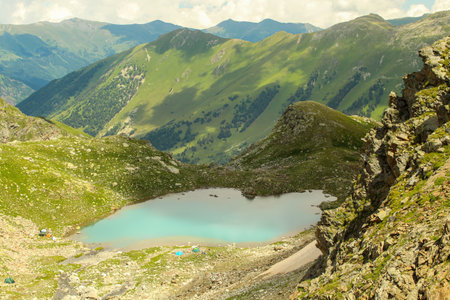 Close up on the small Sophia lake with camps on its bank. Arkhyz, Caucasus, Russia. Background, copy...